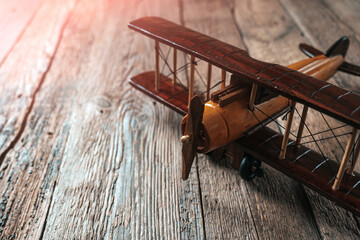 Aviation concept with little toy airplane on the wooden table.