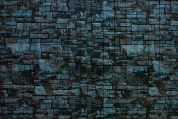 A dark wall of old stone. Brick texture made of uneven elements.