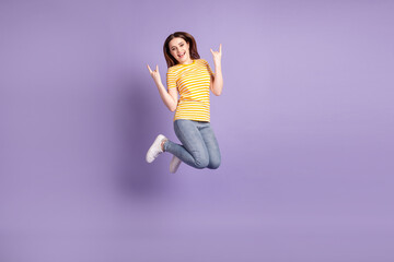 Full size profile side photo of young excited girl jumper show fingers harsh rock metal symbol isolated over purple color background