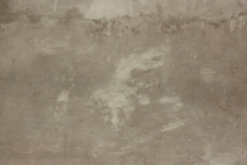 The wall is made of grey untreated concrete with spots. Concrete texture.
