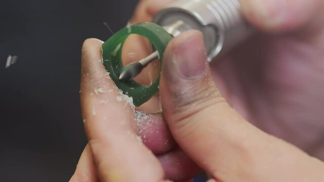 Extreme close up shot of unrecognizable jeweler using flex shaft tool and polishing wax mold ring