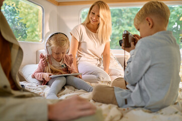 Family with kids relaxing in motorhome, camping