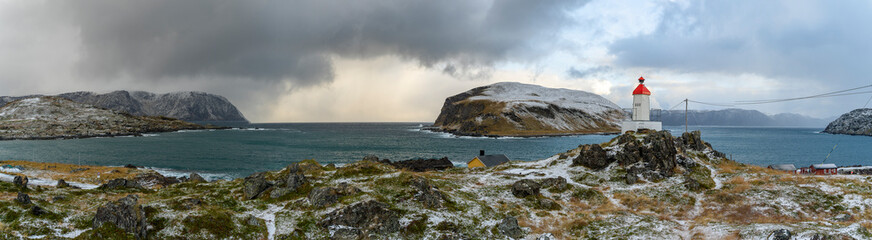 Sturmfront bei Kamøyvær auf Magerøya, mit der Insel Gáhpesuolu. Wilde, steinige Küste mit rot...