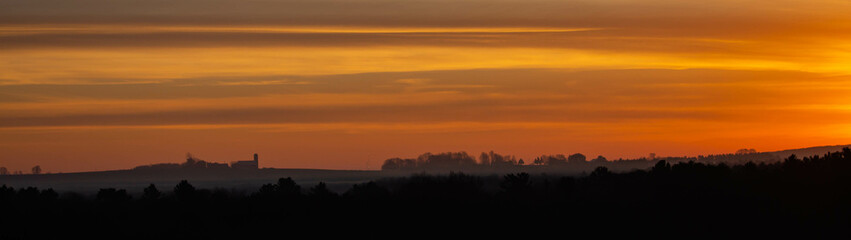 Colorful Wisconsin sunset with silhouette of farm in November