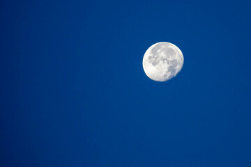 Naklejka na ściany i meble Moon in the waning gibbous phase with blu sky in October