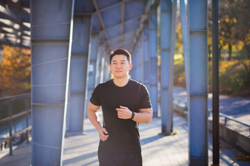 Asian athlete on a morning jog near the stadium, successful male businessman is engaged in fitness in the morning before work