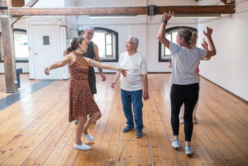 Group of happy Caucasian seniors having fun after dance class. Funny pensioners laughing and fooling around in dance studio after lesson. Dance, hobby, healthy lifestyle concept