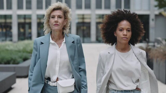 Two diverse business women walking outdoors