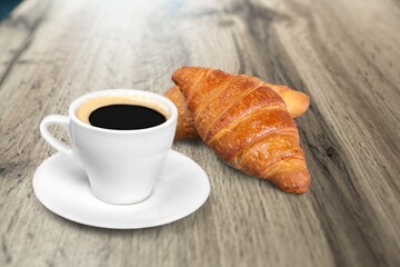 Fresh baked breakfast croissants with cup hot espresso coffee