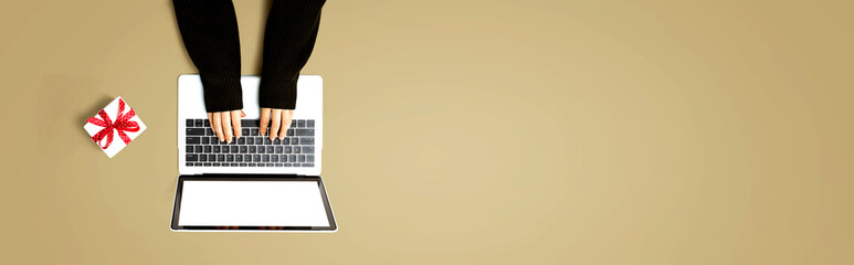 Person using a laptop computer with a gift box from above