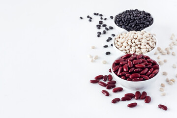Assortment of beans in a white bowl on white background