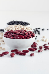 Assortment of beans in a white bowl on white background