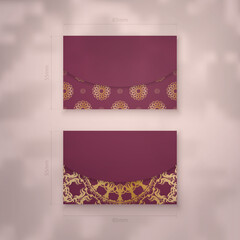 Burgundy business card template with abstract gold pattern for your brand.