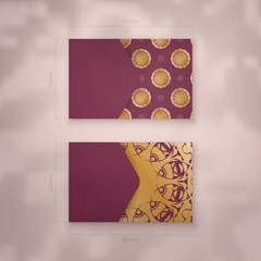 Burgundy business card template with Greek gold ornaments for your brand.