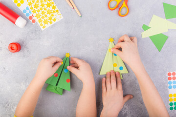 The children decorate paper tree origami. Christmas paper collage. Made with his own hands....