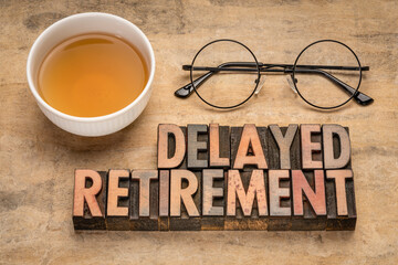 delayed retirement - word abstract in vintage letterpress wood type with a cup of tea and stylish pen, business, career and lifestyle concept