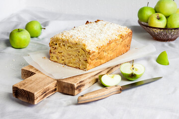 Apple and coconut loaf cake on wooden cutting board