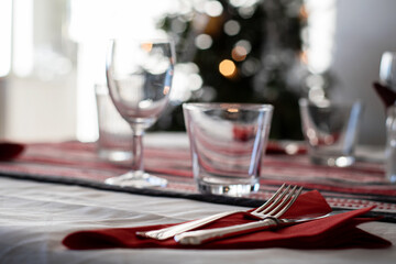 Elegant Christmas table setting with Christmas tree in the background.