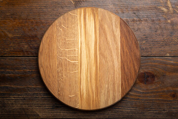Empty round cutting board on a wooden table. Space for text.