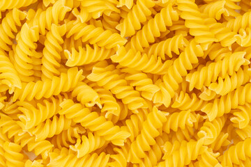 Close-up of raw pasta, texture or background Fusilli. Raw and Dry Macaroni. Italian Culture.