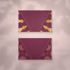 Burgundy business card with abstract gold ornament for your contacts.
