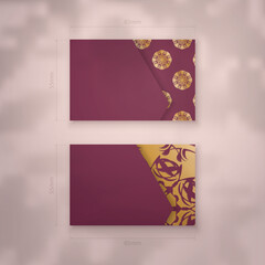 Burgundy business card with Indian gold ornaments for your brand.