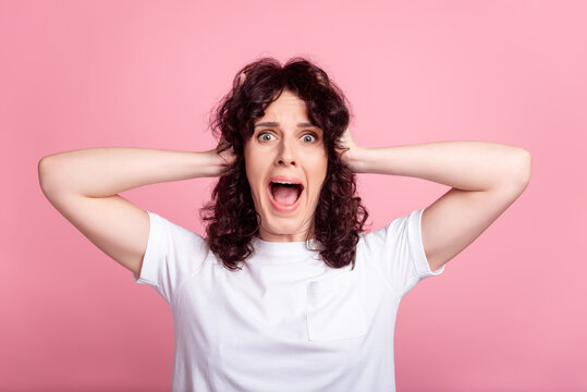 Photo of young woman arms touch head crazy omg unexpected scared isolated over pink color background