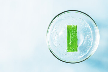 Organic facial serum with aloe in a glass jar. Natural skin care product top view with space for text