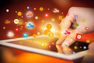 Close-up of a hand using tablet with social media icons