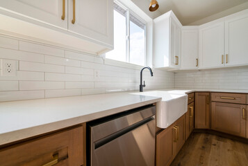 Kitchen sink with subway tiles backsplash, marble top with cabinets and dishwasher below