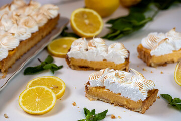 Obraz na płótnie Canvas Lemon cake with protein cream, on a light background, with lemon slices and mint leaves. 