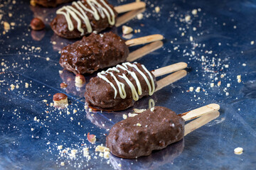 Ice cream on a stick covered with nuts and chocolate glaze.