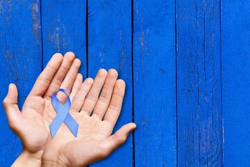 Blue ribbon cancer. Awareness prostate cancer of men health in November. Ribbon in hands