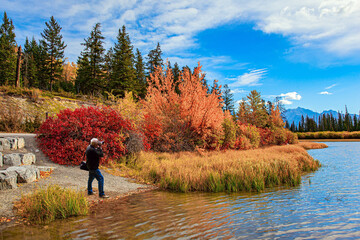 Elderly man takes pictures of lake