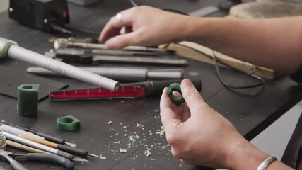 PAN close up of unrecognizable female jeweler using sizing mandrel and creating wax mold for ring, then measuring it with caliper