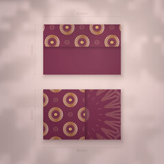 Business card in burgundy color with abstract gold pattern for your contacts.