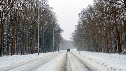 Driving in a snowstorm on a country road in the Netherlands