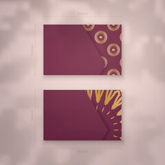 Business card in burgundy color with vintage gold ornaments for your brand.