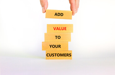 Add value to your customers symbol. Concept words 'Add value to your customers' on wooden blocks on a beautiful white background, copy space. Businessman hand. Business, customers value concept.