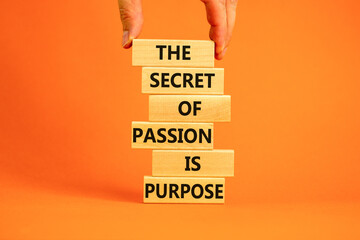 Passion and purpose symbol. Wooden blocks with concept words The secret of passion is purpose. Beautiful orange background, copy space. Businessman hand. Business, passion and purpose concept. - obrazy, fototapety, plakaty