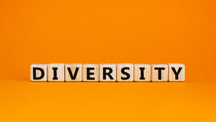 Diversity and better inclusion symbol. The concept word Diversity on wooden cubes. Beautiful orange table, orange background. Business, inclusion and diversity concept, copy space.