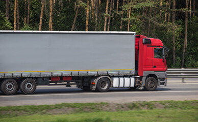 Fototapeta na wymiar Semi-trailer truck moves along a suburban highway