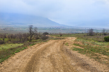 Fototapeta na wymiar Dirt road to the village in the mountains
