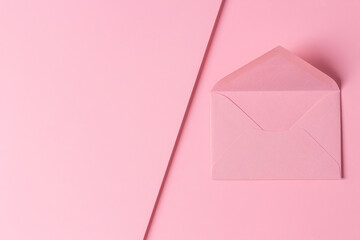 One empty pink envelope on pastel pink geometric background. Top view, copy space for text