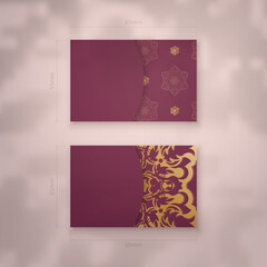 Business card template in burgundy color with abstract gold ornament for your contacts.