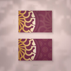 Business card template in burgundy color with abstract gold ornaments for your brand.