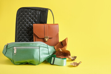 brown, black and green eco leather bags and mushrooms on a yellow background, vegan leather