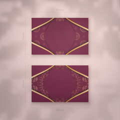 Business card template in burgundy color with luxurious gold ornaments for your contacts.