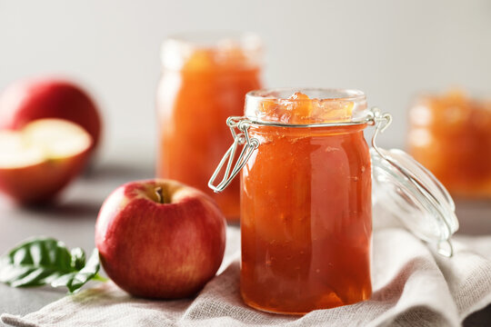 Apple jam in a glass jar. Apple jam on a light background. Delicious natural marmalade.