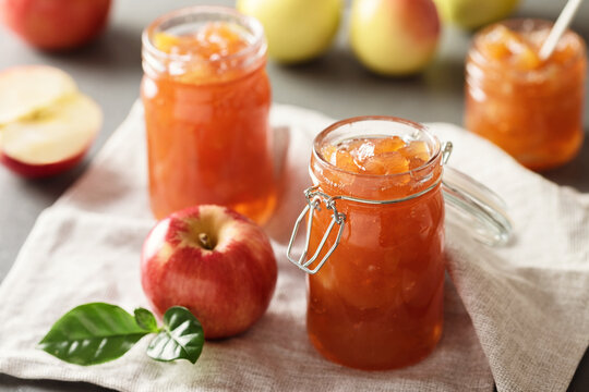 Apple jam in a glass jar. Apple jam on a light background. Delicious natural marmalade.